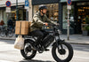 Dual battery electric cargo bike carrying cargo boxes for delivery in an urban setting
